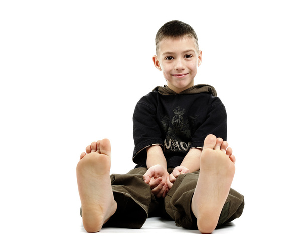 Little boy sitting barefoot, isolated on white - Foto, imagen