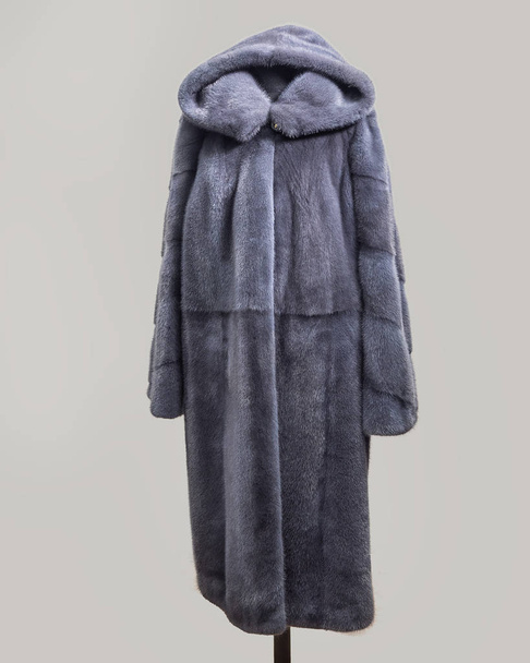 Gray mink coat straight cut with undercut yoke on the chest and striped sleeves for the store catalog - Fotó, kép
