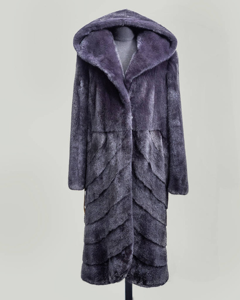 Млинцеве пальто бузково-сірого кольору з декоративною спідницею з косою смуги хутра з капюшоном, вертикальна рамка
 - Фото, зображення