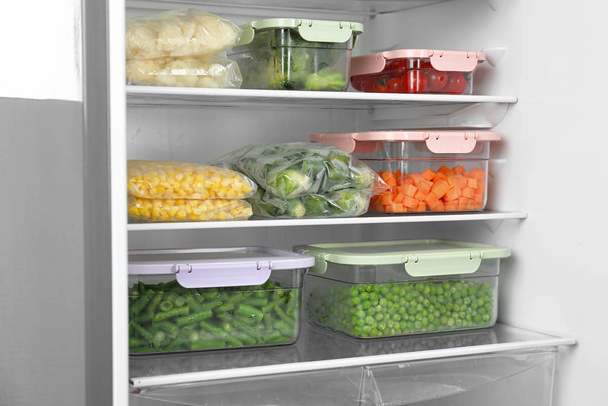 Plastic bags and containers with different frozen vegetables in refrigerator - Valokuva, kuva