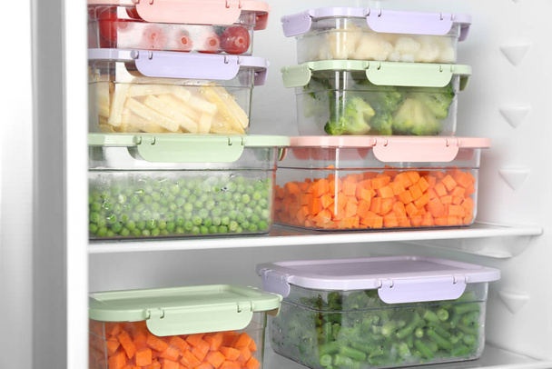Containers with different frozen vegetables in refrigerator - Foto, imagen