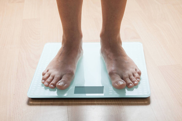 The legs of a young woman on the scales. Weight check. The concept of losing weight. - Fotó, kép