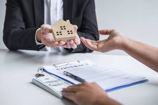 Agente inmobiliario que envía el modelo de la casa al cliente después de firmar el acuerdo
 - Foto, imagen