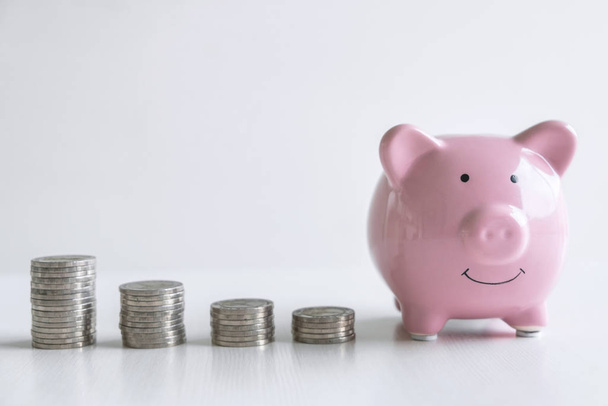 Afbeeldingen van stapel munten stapel en roze lachende Piggy Bank naar Gro - Foto, afbeelding