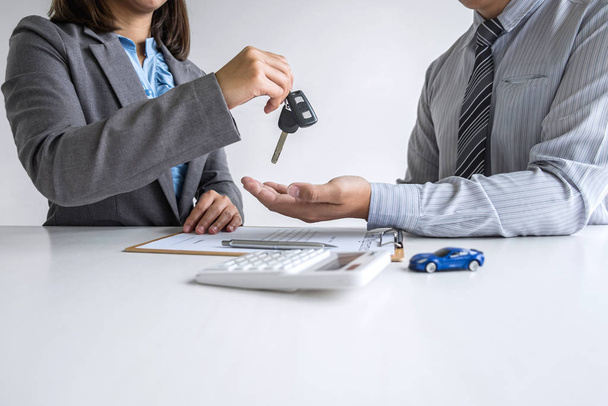Car rent agent manager holding key of new car giving to business - Photo, Image