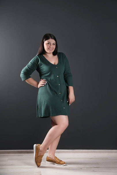 Beautiful overweight woman posing near black wall. Plus size model - Fotoğraf, Görsel