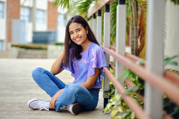 glimlachen dominicaanse 20 jaar oud meisje outdoor campus universiteit - Foto, afbeelding