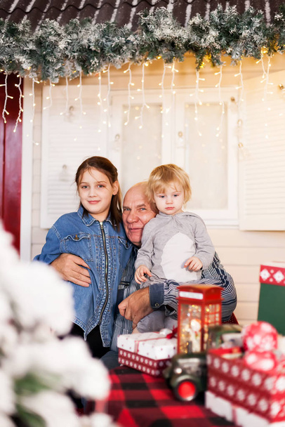 Großvater mit Enkelinnen im neuen Jahr mit Geschenken.  - Foto, Bild