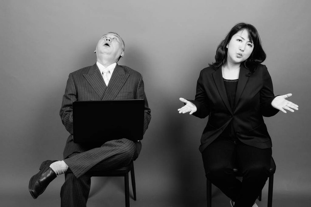 Mature Asian businessman and mature Asian businesswoman together - 写真・画像