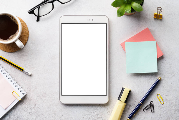 A tablet with white blank screen on an office desk. Flat lay. - Foto, Bild
