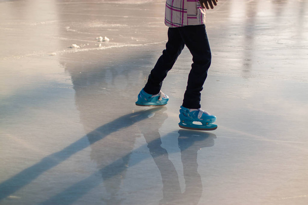 feet of different people skating on the ice rink. Hobbies and recreation. Sports and holidays. - 写真・画像