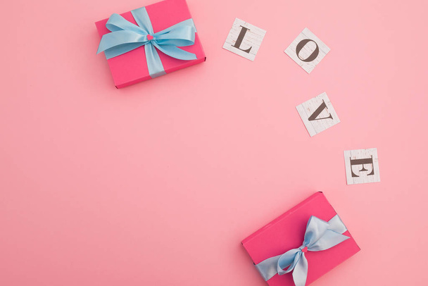 Sevgililer Günü konsepti. Aşk kelimesi ve hediye kutusu pembe sırt çantasında. - Fotoğraf, Görsel