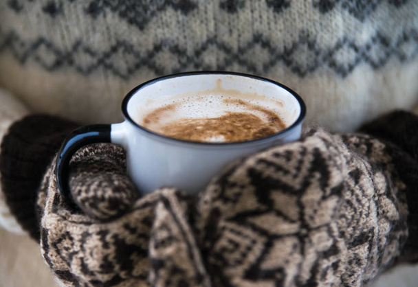 mujer está sosteniendo taza de café con leche en guantes calientes
 - Foto, Imagen