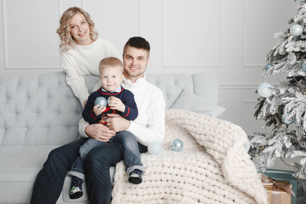 Matka, ojciec i syn siedzą na kanapie i uśmiechają się - Zdjęcie, obraz
