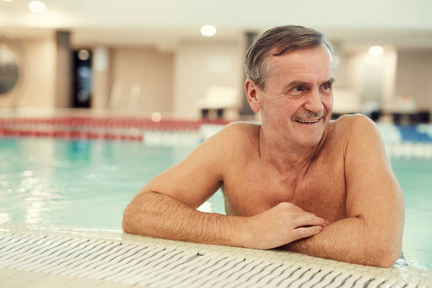 Πορτρέτο του σύγχρονου ηλικιωμένου που απολαμβάνει την πισίνα ενώ χαλαρώνει στο πολυτελές θέρετρο Spa, αντιγραφή χώρου - Φωτογραφία, εικόνα