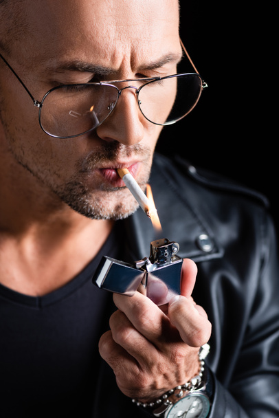 schöner Mann mit Sonnenbrille zündet Zigarette mit Feuerzeug an - Foto, Bild