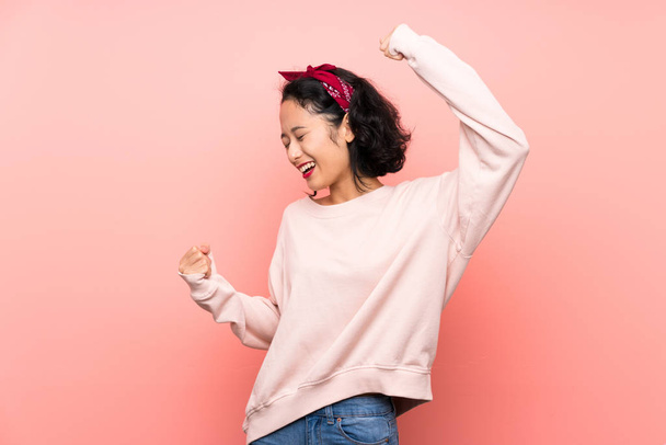 Asian young woman over isolated pink background celebrating a victory - Valokuva, kuva
