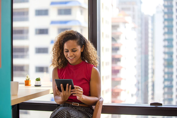 Tiro de cabeça de sorrir afro-americano millennial feminino usando laptop ou tablet
 - Foto, Imagem