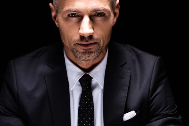 Portrait of handsome businessman looking at camera isolated on black  - Фото, зображення