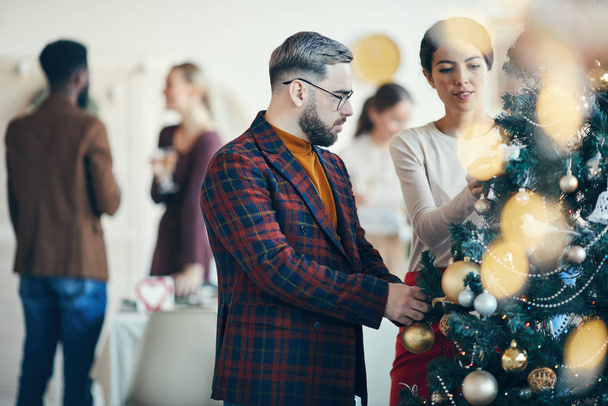 Side view portrait of modern adult man looking at Christmas decorations during banquet party, copy space - 写真・画像