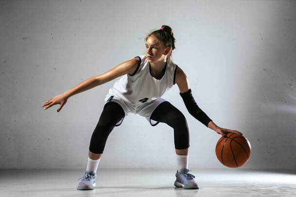 Young caucasian female basketball player against white wall background - Foto, immagini