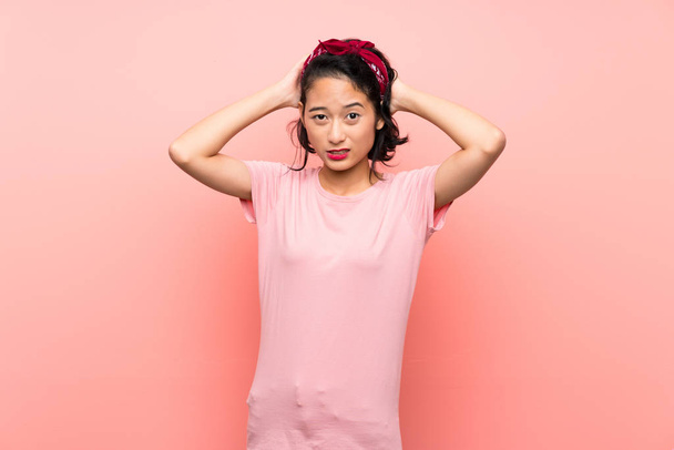 Azji młoda kobieta na odizolowanym różowym tle sfrustrowany i bierze ręce na głowę - Zdjęcie, obraz