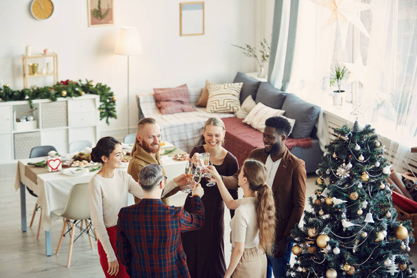 High angle view at group of elegant people enjoying Christmas party and drinking champagne in beautiful dining room, copy space - 写真・画像
