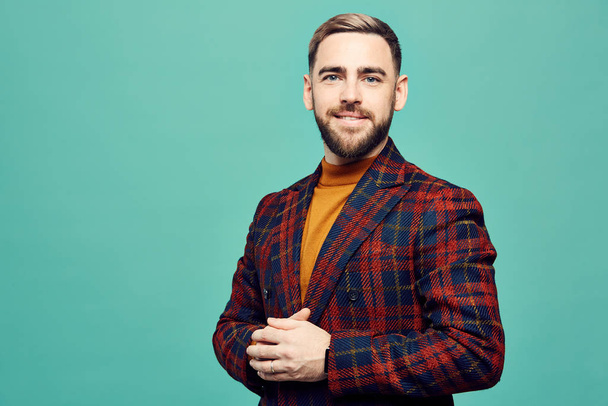 Waist up portrait of successful bearded man smiling at camera while posing against mint green background, copy space - Photo, Image