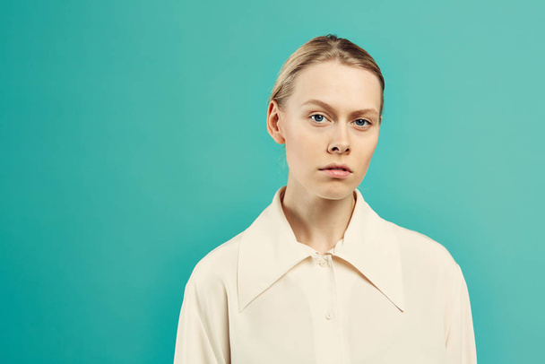 Waist up portrait of young contemporary woman looking at camera with serious face expression while posing against mint blue background, copy space - Фото, изображение