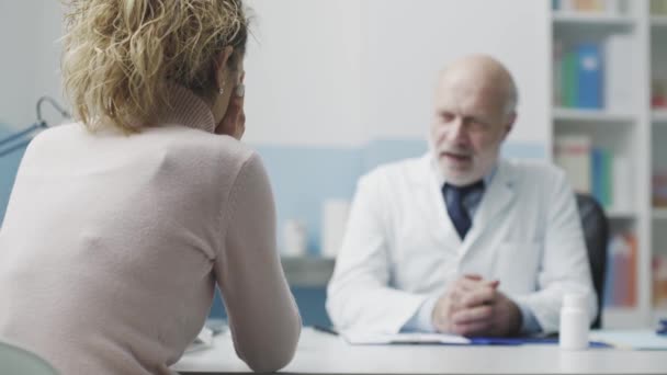 Doctor giving a bad diagnosis to a patient - Imágenes, Vídeo