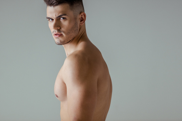 sexy muscular bodybuilder with bare torso looking at camera isolated on grey - Φωτογραφία, εικόνα