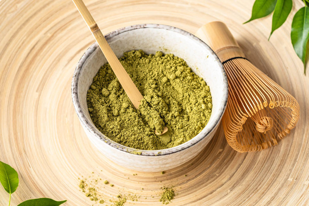 Japanese matcha green tea powder, a healthy natural product, antioxidant. Bamboo spoon and whisk. - Photo, image