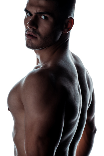 sexy musculoso culturista con torso desnudo posando en sombra aislado en blanco
 - Foto, Imagen