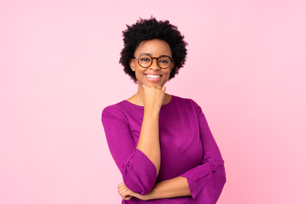 Mujer afroamericana sobre fondo rosa aislado con gafas y sonriente
 - Foto, Imagen