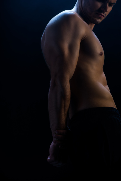 cropped view of sexy muscular bodybuilder with bare torso on black background - Fotografie, Obrázek