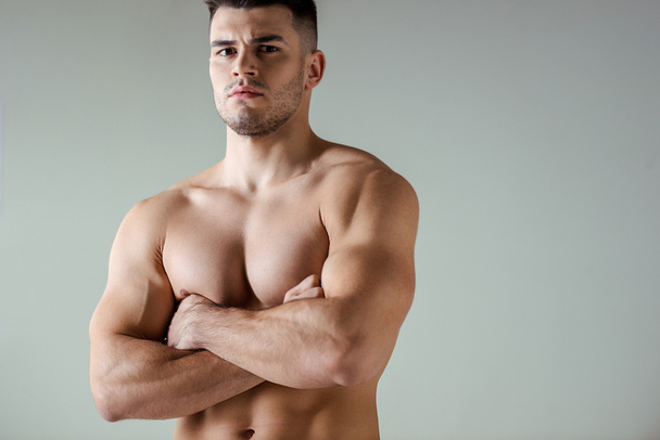 sexy musculoso culturista con torso desnudo posando con brazos cruzados aislados en gris
 - Foto, imagen