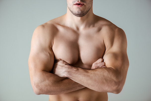 vue recadrée de bodybuilder musclé sexy avec torse nu posant avec les bras croisés isolés sur gris
 - Photo, image