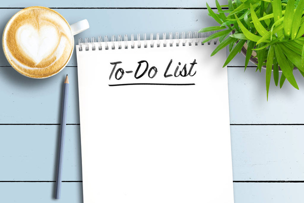 spiral bound notebook with To-Do List on white wooden table with potted plant and cup of coffee - Photo, Image