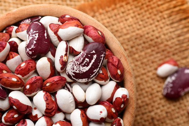 Beans in wooden bowl on sackcloth background - Zdjęcie, obraz