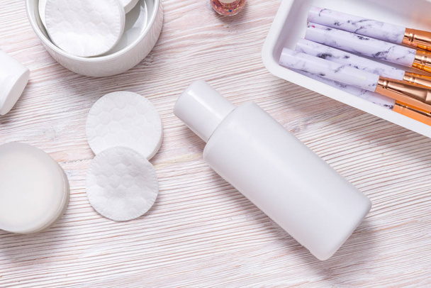 Set of plastic bottles for cream or face lotion on wooden table - Foto, afbeelding