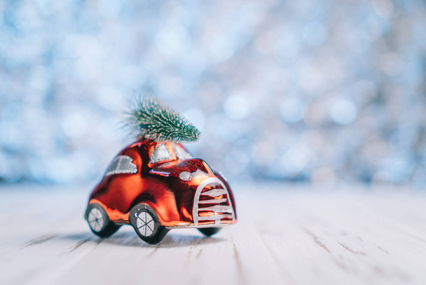 Little red toy car carries a Christmas tree - Foto, Bild