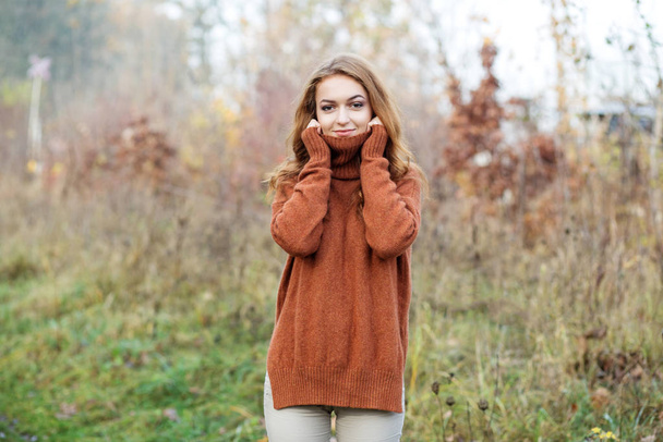 erwachsene schöne Frau in einem hellbraunen Pullover. Natur. Lifestylekonzept, Herbst, Kosmetik und Pflege. - Foto, Bild