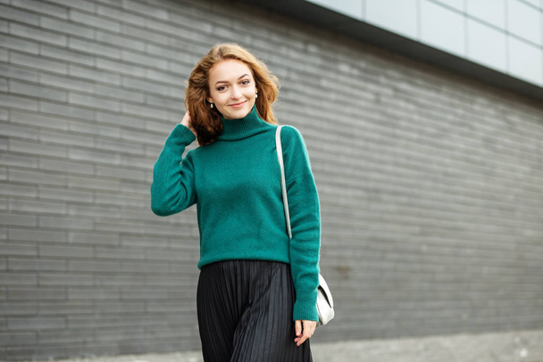 Красива доросла жінка посміхається. Зелений в'язаний светр. Концепція моди, способу життя, міського
. - Фото, зображення
