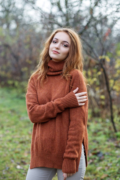 Adult beautiful girl in a light brown sweater. Nature. The concept of a lifestyle, autumn, cosmetics and care. - Photo, Image