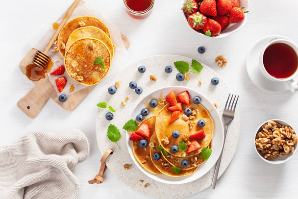 pancakes with blueberry strawberry honey and nuts for breakfast - Foto, Imagen