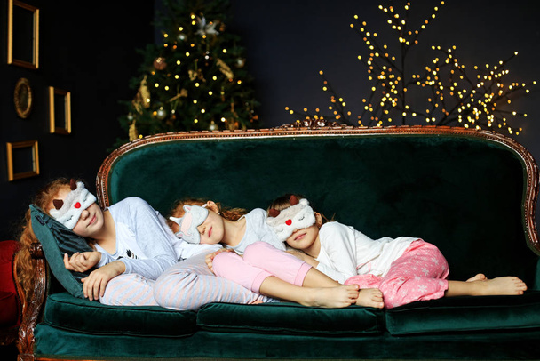 Három lány gyerek alszik pizsamában. A koncepció Boldog Karácsonyt, Ünnepeket, Újévet, család és ajándékok. - Fotó, kép