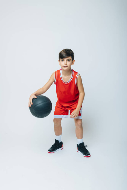 Boy playing basketball on studio - Foto, afbeelding