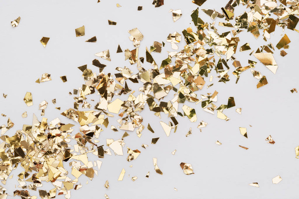 Gold leaf confetti on white background Diagonal spread holiday glitter backdrop. - Photo, Image