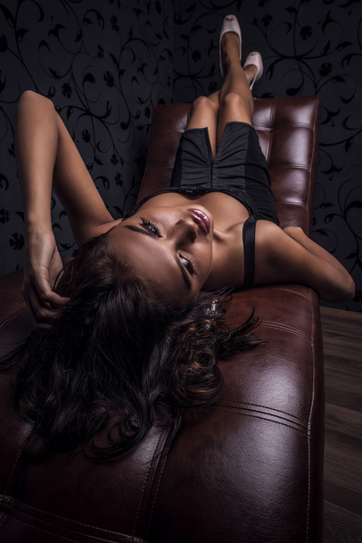 Young sensual & beauty woman posing on luxury leather sofa. - Foto, imagen