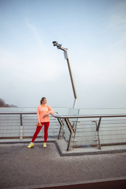 Lady in sportswear standing on the bridge - Foto, Imagem